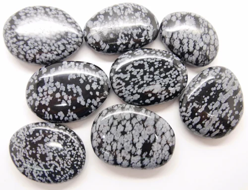 Obsidiana nevada rodada en primer plano mostrando su brillo plateado y tacto pulido
