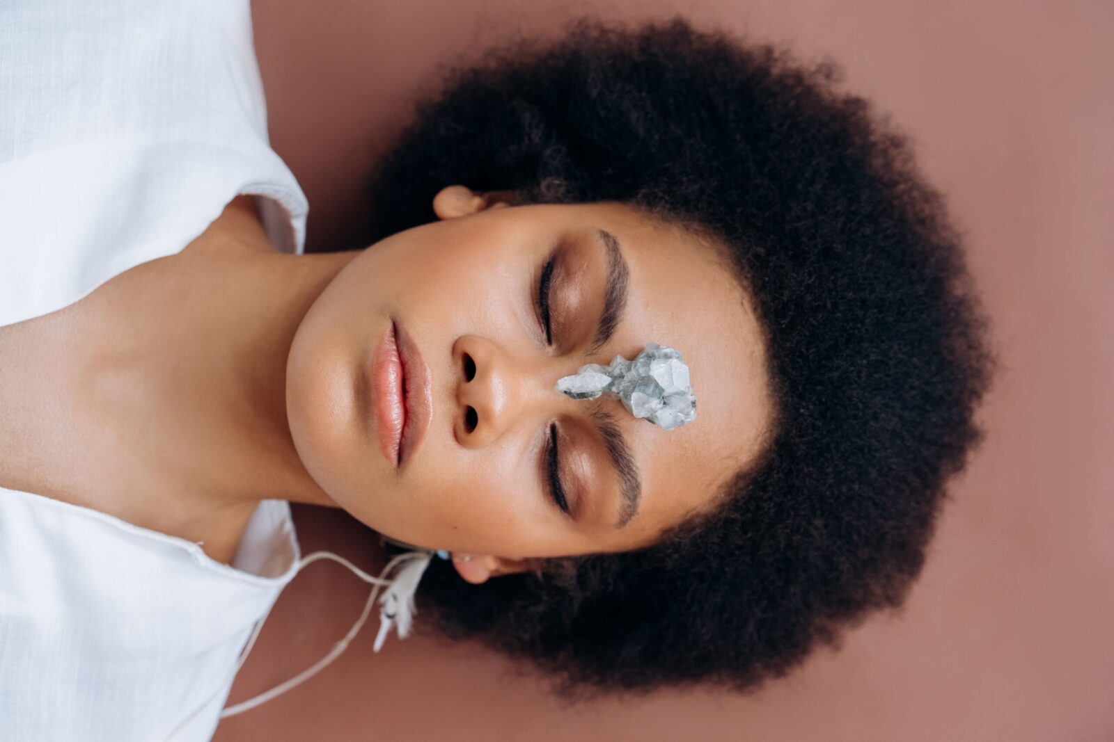 Los 10 cristales más poderosos para la meditación 12 Woman practicing meditation with healing crystal on forehead, promoting wellness and relaxation.