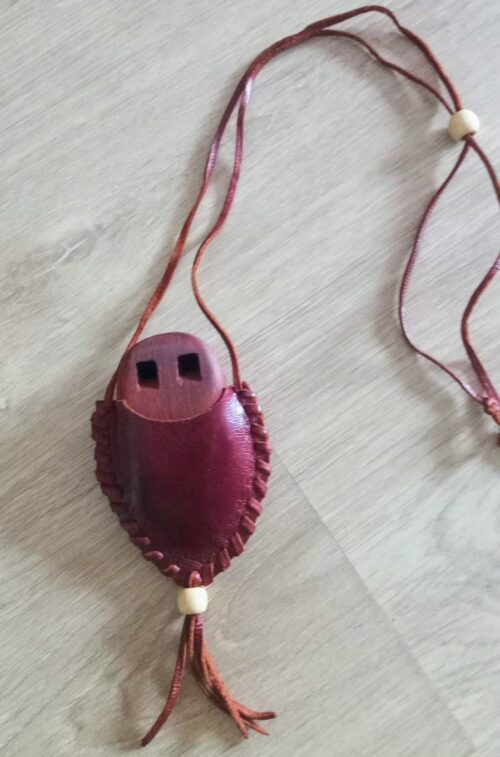 Silbato llamador águila con funda de cuero sobre fondo neutro